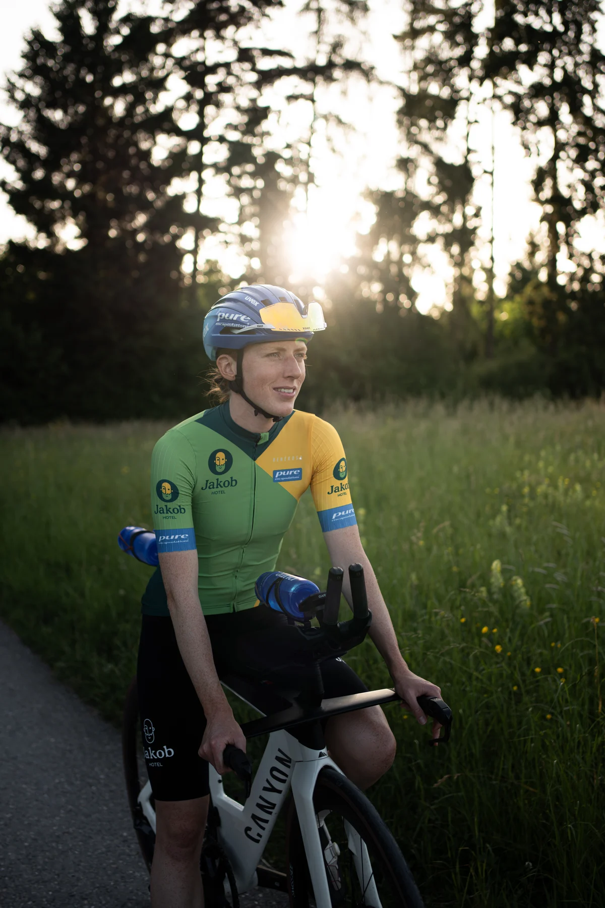 Leana im Teamdress mit ihrem Rad im Abendlicht